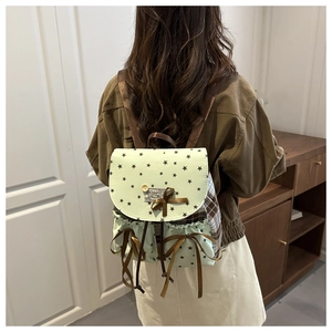 Close-up of a sweet plaid backpack with green star pattern and bow tie details