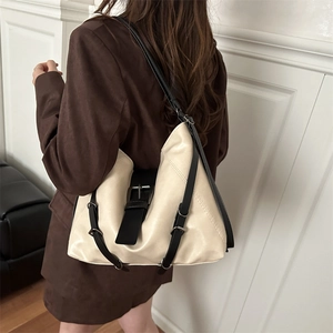 Elegant off-white faux leather tote bag with black contrast straps shown on female model