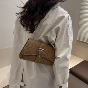 Vintage brown monogram crossbody bag with silver chain strap shown on model shoulder