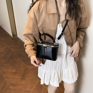 Retro black patent leather box bag with handle and strap shown on a model
