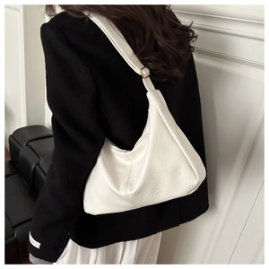 Detailed side view of white faux leather hobo shoulder bag with textured pleats on strap