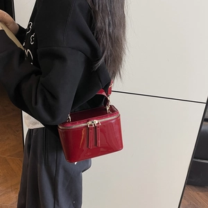 Chic red patent leather box bag with a glossy mirror finish and gold zipper detail
