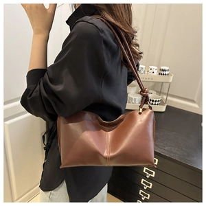 Detail of brown PU leather underarm bag with vertical stitching and slim strap