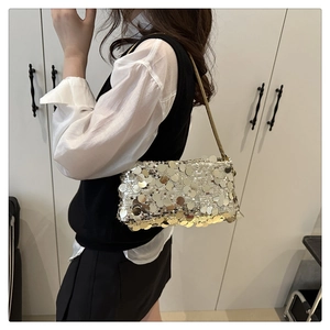 Details von schimmernden Silberpailletten und zarter Metallkette an schicker Schultertasche