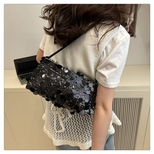 Détails des paillettes noires brillantes sur un sac porté épaule élégant par un mannequin
