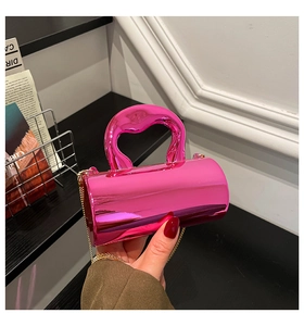 Detail of a pink cylindrical vanity bag with metallic finish and gold chain strap