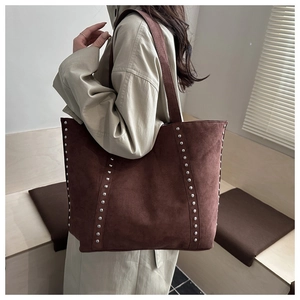 Vue détaillée du grand sac cabas en daim marron foncé orné de rivets métalliques