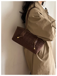 Detail of dark brown leopard print shoulder bag with gold metal knot and logo