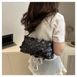 Détail d'un sac à épaule chic à paillettes noires dans un décor de style minimaliste