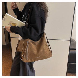 Détail du sac hobo marron vintage avec fermeture éclair à franges et mini porte-monnaie