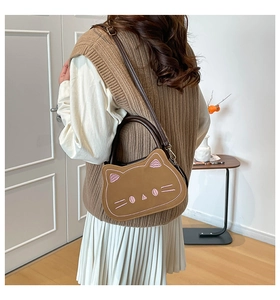 Détail du sac chat marron avec broderie rose porté dans un décor de style de vie chaleureux