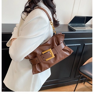 Détail du sac en cuir marron foncé avec plis souples et grande boucle carrée dorée