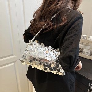 Sac à bandoulière en sequins argentés avec fine sangle métallique porté par un mannequin