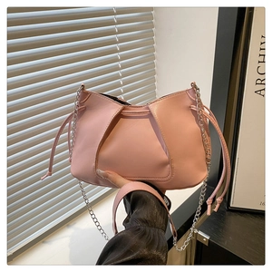 Dettaglio borsa in pelle rosa con pieghe a coulisse e sottile tracolla a catena argento