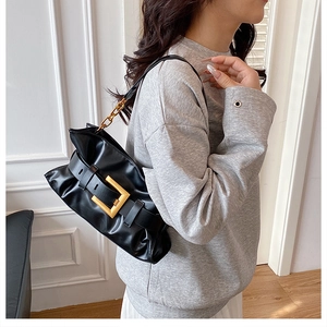 Détail du sac d'épaule en cuir PU noir avec grande boucle dorée et côtés froncés