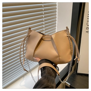 Dettaglio borsa a mezzaluna beige con pieghe, coulisse e tracolla a catena argento