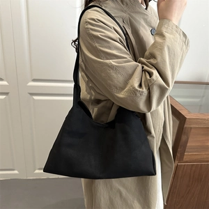 Minimalist black suede tote bag with geometric design for stylish urban commuting style