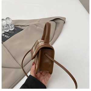 Detail of a brown leather and plaid tweed mini crossbody bag showing side thickness and handle