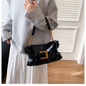 Détail du sac cabas plissé noir avec boucle dorée et bandoulière en chaîne dorée