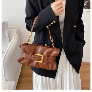 Détail du grand sac cabas en cuir marron avec boucle dorée et bandoulière en chaîne