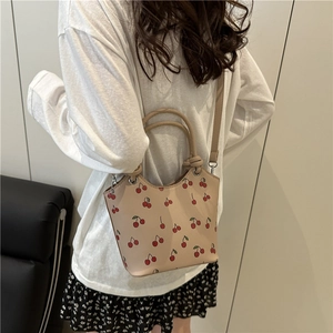 Chic beige shoulder bag with cherry print and dual handles for casual commuting