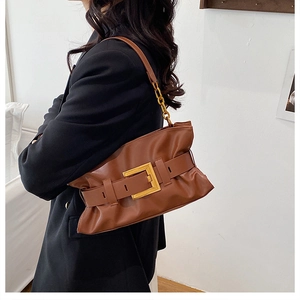 Détail du sac fourre-tout en cuir marron avec boucle dorée et bandoulière en chaîne