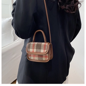 Close-up of vintage brown plaid tweed crossbody bag with synthetic leather handles