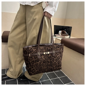 Detail der Wildleder-Tragetasche mit Leopardenmuster, Goldschließe und braunem Griff