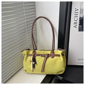 Détail du sac cabas en daim vert avec bandoulières en cuir marron et perles en bois