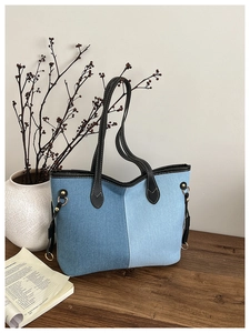 Détail du sac cabas en denim avec design patchwork et anneau métallique doré élégant