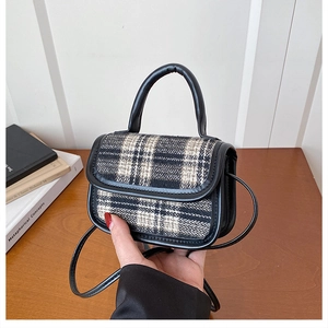 Detail of mini plaid crossbody bag in black and white tweed with elegant leather trim