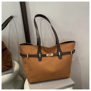 Detailansicht der braunen Wildledertasche mit goldener Schnalle und edler Textur im Fokus