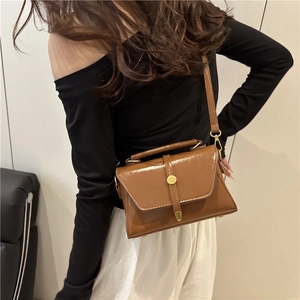Brown oil wax leather crossbody bag for women with top handle and gold buckle
