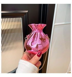 Close-up of bright pink glossy mirror bag with wavy draw-string top and gold chain strap