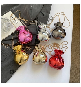 Detail of colorful mini metallic drawstring bags with elegant chain straps on table
