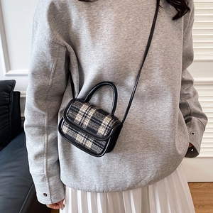 Minimalist black and white plaid crossbody bag with leather trim on model