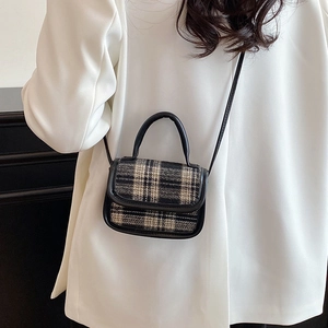 Minimalist black and white plaid crossbody bag with leather trim on white blazer