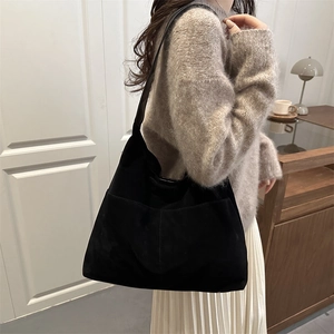 Grand sac fourre-tout noir minimaliste avec poche avant dans un décor d'intérieur