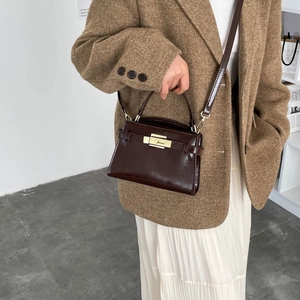 Sac bandoulière tendance en cuir verni marron foncé avec boucle dorée et poignée
