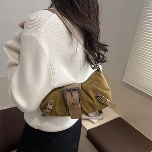 Chic olive green canvas underarm bag with vintage leather straps worn by a model