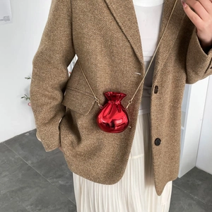 Metallic red bucket bag with gold chain strap worn with a brown tweed blazer