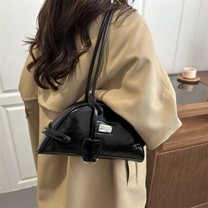 Minimalist black crescent leather underarm bag with silver logo on khaki trench coat