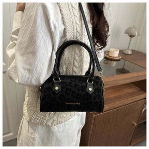 Detail of black leopard print Boston bag with leather handles and fashion slogan