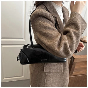 Dettaglio della borsa sottobraccio nera lucida in vernice con testo Fashion & Bags chic