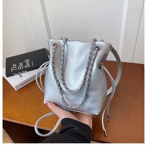 Close-up of a silver bucket bag with Fashion Bags text and woven metal chain strap detail