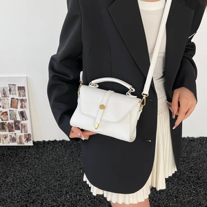 Chic white textured leather crossbody bag with gold hardware shown on a model
