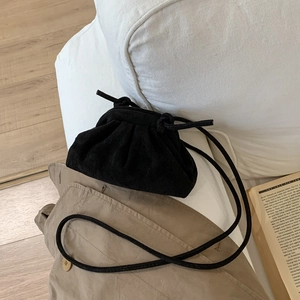 Détail du sac nuage froncé noir sur un manteau kaki avec décor esthétique