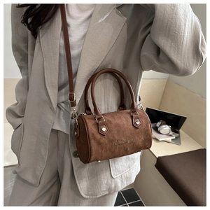 Detailed close-up of dark brown suede Boston bag with MiDoLnu logo and leather handle