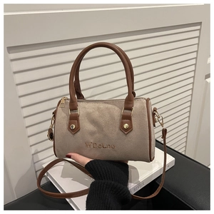 Detail of retro Boston bag in beige frosted suede with brown leather handles and gold hardware