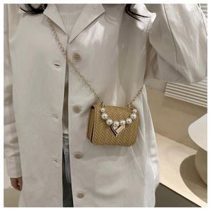 Detail of khaki woven mini bag with pearl handle and heart-shaped metal lock